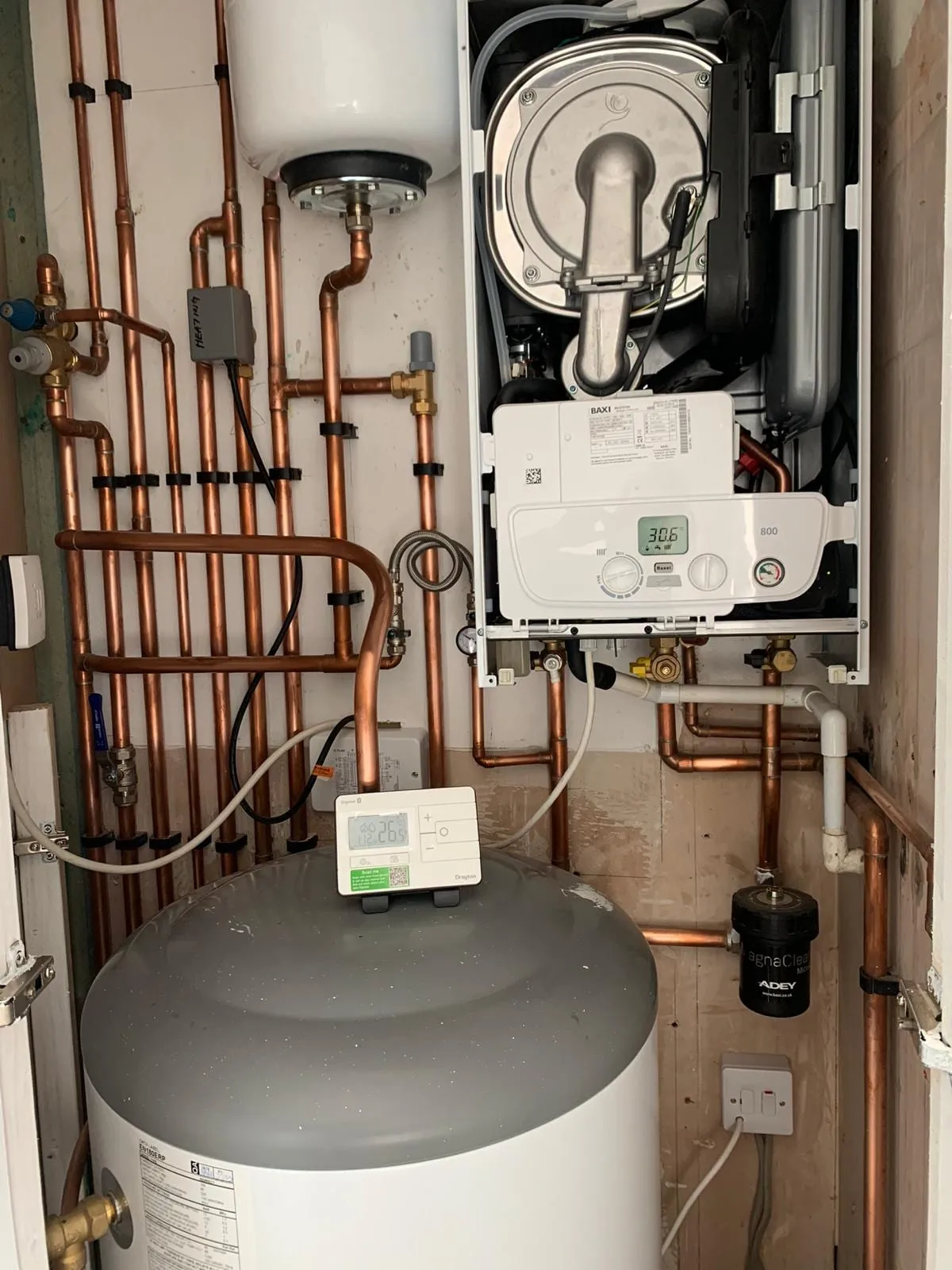 A boiler, a cylinder and a system filter installed together with copper pipework in a utility space