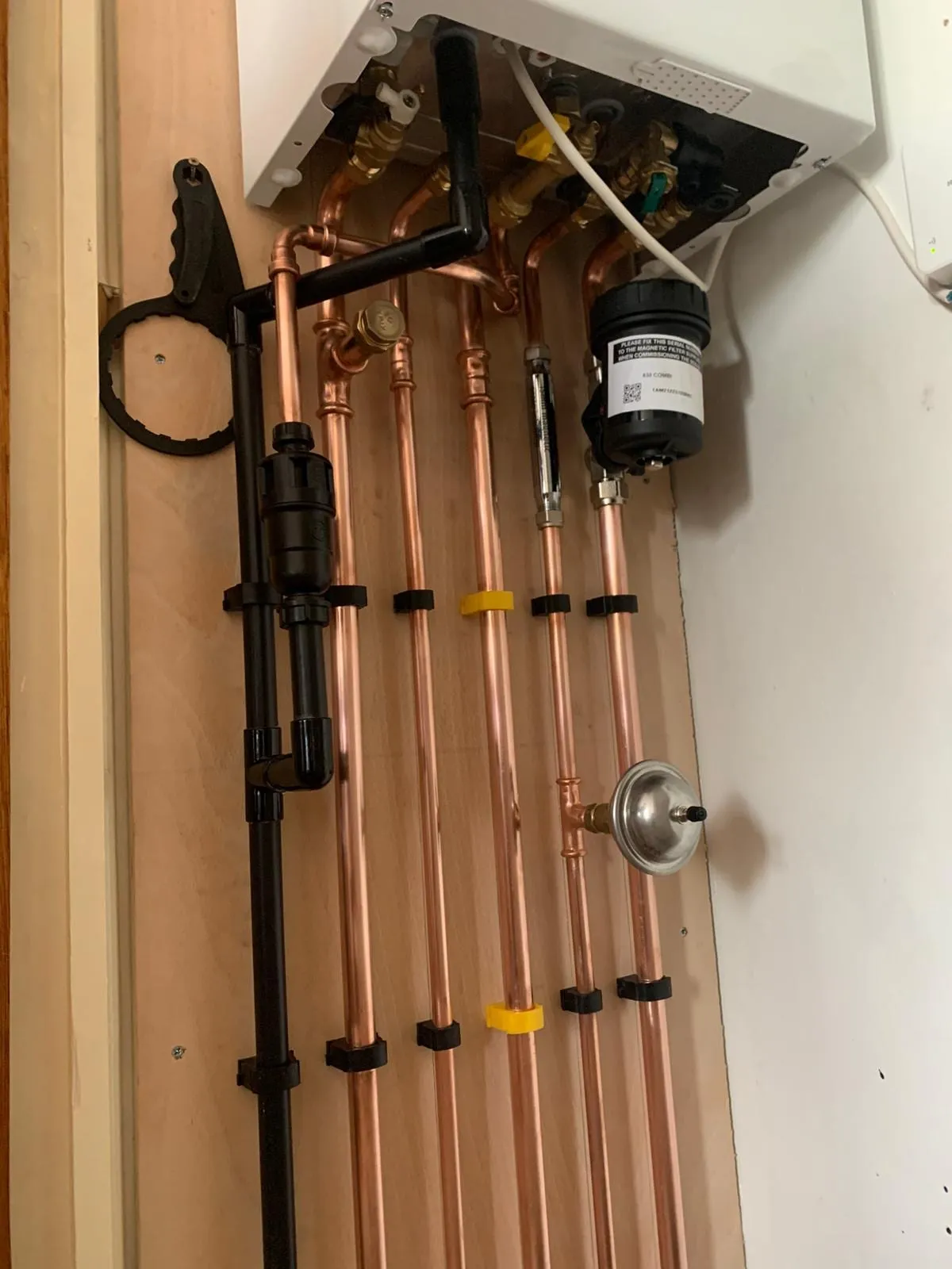 A copper pipework board with valves, a pump and gauges built up before boarding out