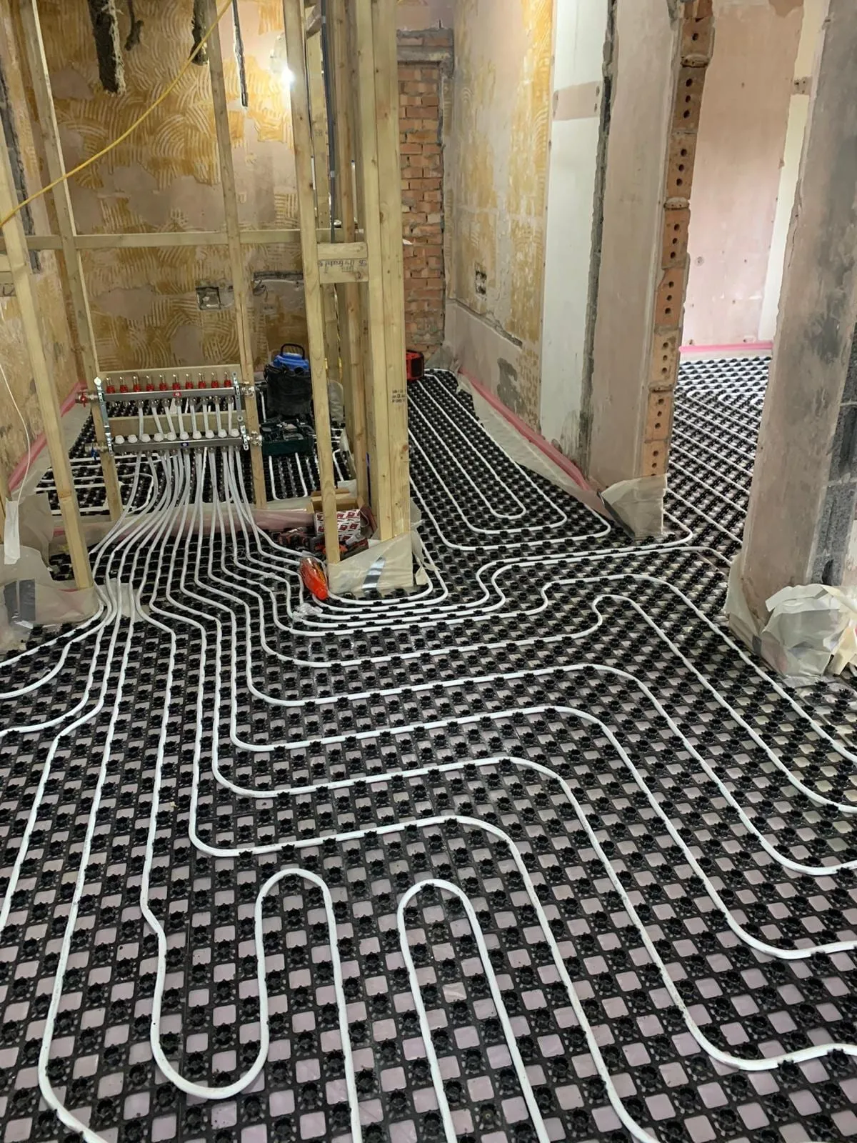 Underfloor heating pipe laid through a house under construction, following the room shapes